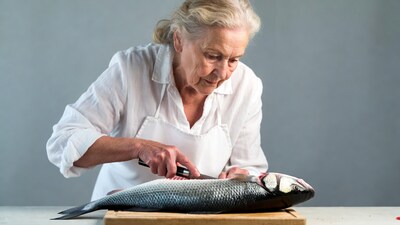 Elderly woman filleting fish