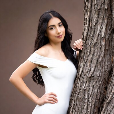 Latina woman leaning on tree