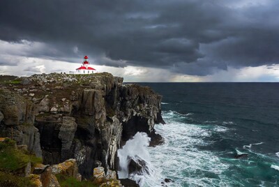 Red Lighthouse on Stormy Cliff Over Ocean