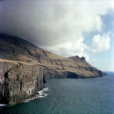 Dramatic cliffs over ocean with clouds