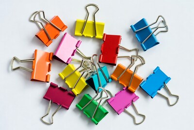 Colorful binder clips on white background