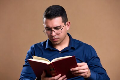 Latino man reading red book