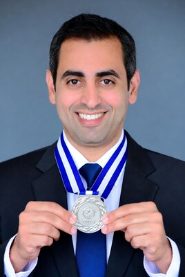 Man holding silver medal in suit