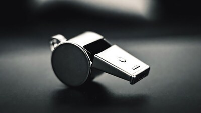 Shiny metal whistle on black background