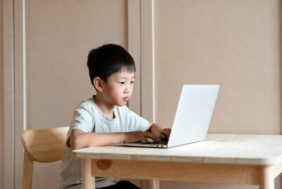 Asian boy using laptop at table