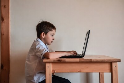 Boy typing on laptop at table