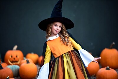 Girl in witch costume with pumpkins