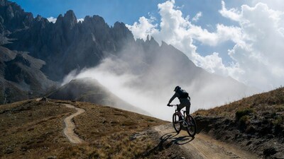 Mountain biker on trail with peaks
