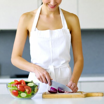 Asian woman chopping onions in apron