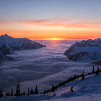 Sunrise over snowy mountains and sea of clouds