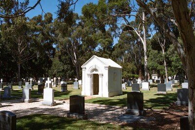 White Mausoleum in Tree-Lined Cemetery
