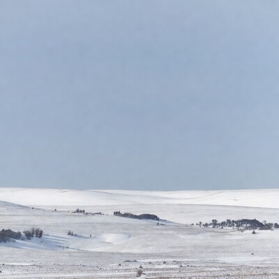 Snowy Hills with Trees Under Blue Sky
