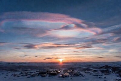 Sunrise Over Snowy Arctic Village with Cloud Halo