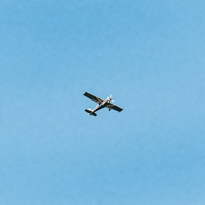 Small propeller plane flying in blue sky