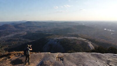 Man using binoculars on mountain overlook