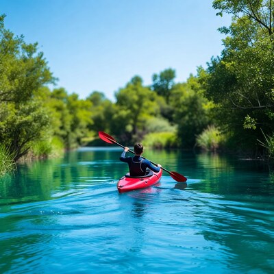 Man kayaking in red kayak on river