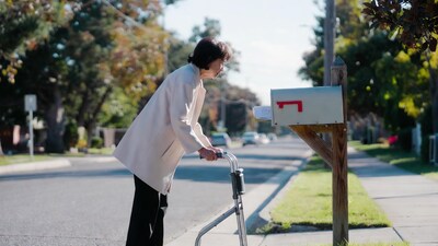 Elderly woman checking mailbox with walker