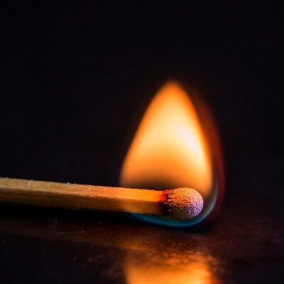 Burning Matchstick on Black Background