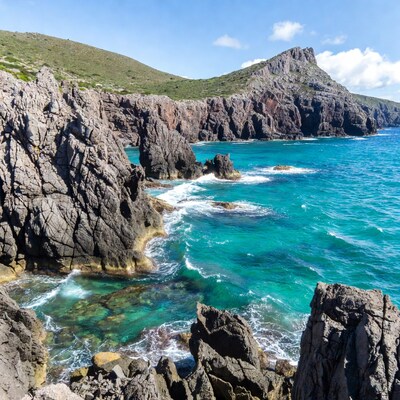 Turquoise sea crashing on rugged cliffs