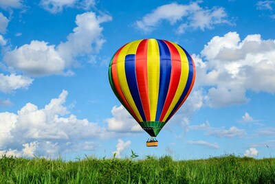 Colorful hot air balloon over grass field