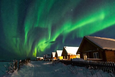 Northern Lights over Snowy Cabins