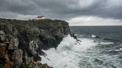 Lighthouse on Cliff Over Crashing Waves