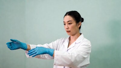 Asian woman wearing blue gloves lab coat