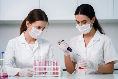 Two women scientists pipetting lab test tubes