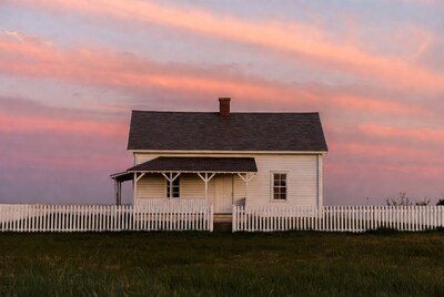 White house with porch at pink sunset
