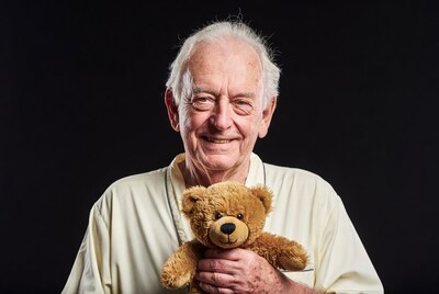Elderly man holding teddy bear