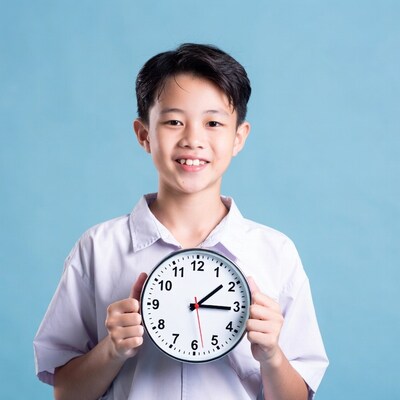 Asian boy holding clock