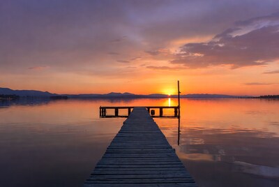 Wooden pier over lake at sunset