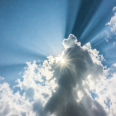 Sun rays through clouds in blue sky