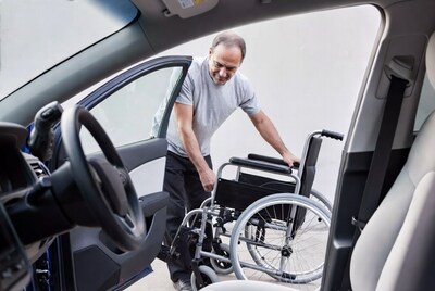 Man loading wheelchair into car