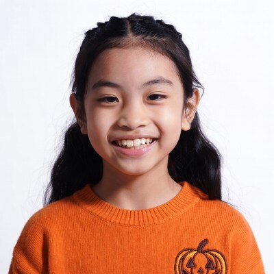 Asian girl smiling in Halloween sweater