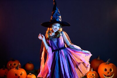 Girl in Witch Costume with Pumpkins