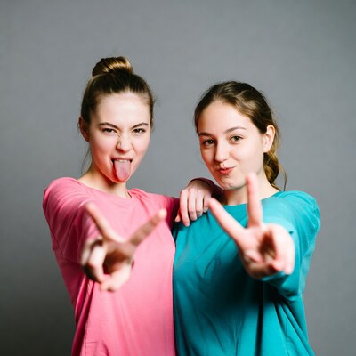 Girls sticking tongues out with peace signs