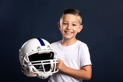 Boy holding football helmet
