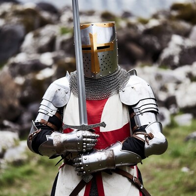 Knight in armor holding sword outdoors