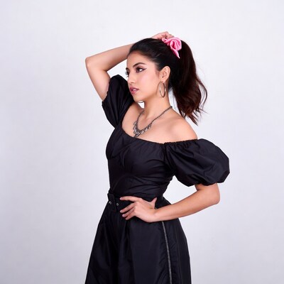 Woman in black puff sleeve dress with pink scrunchie