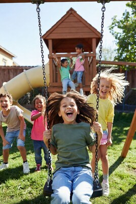 Girl swinging with friends at playground