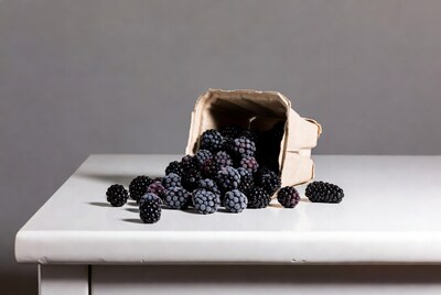 Blackberries spilling from paper bag