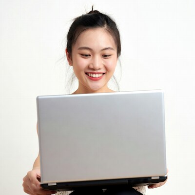 Asian woman smiling at laptop