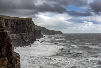 Stormy Sea Crashing Against Cliffs