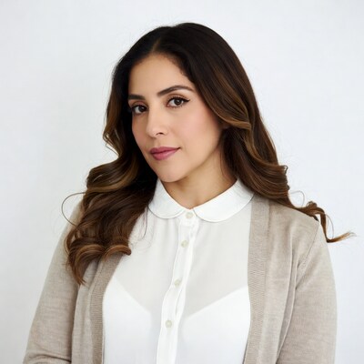 Latino woman in white blouse and beige cardigan