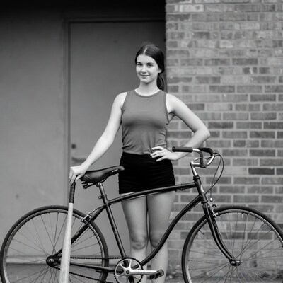 Girl with bicycle and bat