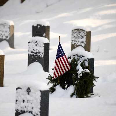 American flag on snowy gravestone