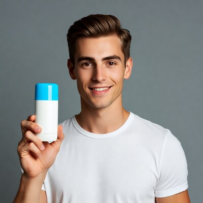 Handsome man holding deodorant stick