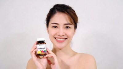 Asian woman holding vitamins bottle