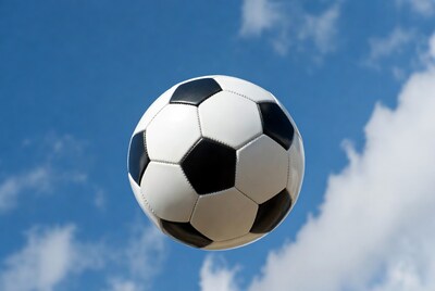 Soccer Ball Flying in Blue Sky